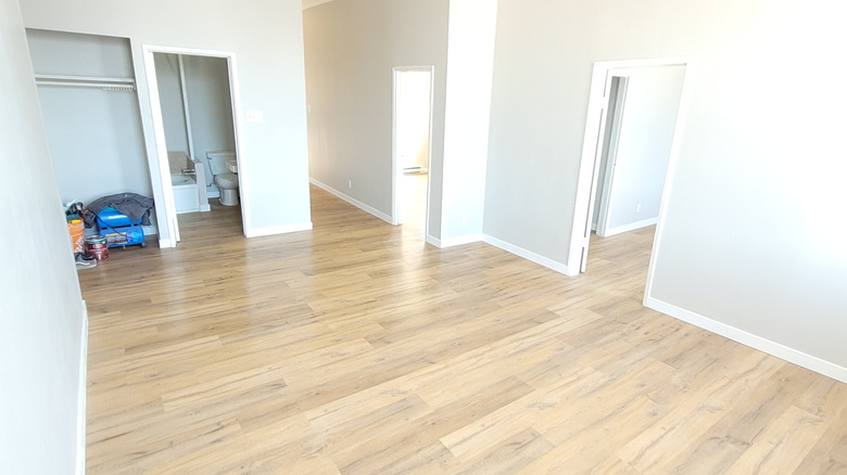 An empty bedroom with white walls and luxury vinyl plank flooring