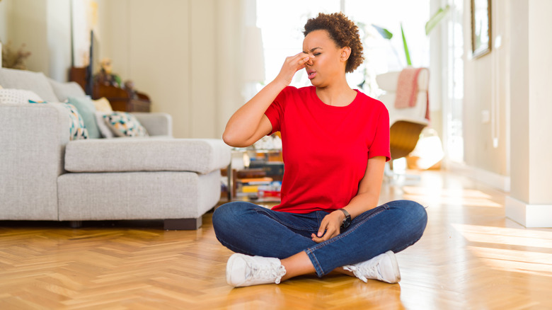 woman sitting on floor bad smell