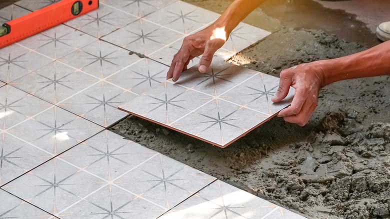 Person installing ceramic tiles