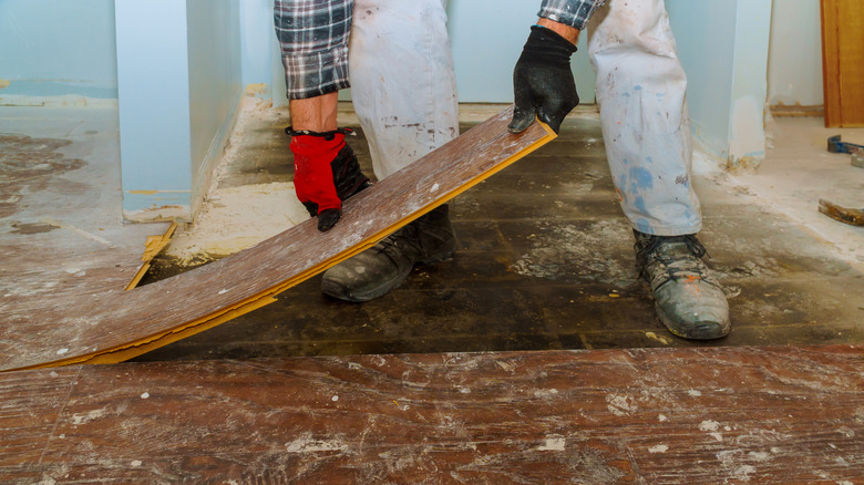 Contractor pulling up old vinyl flooring
