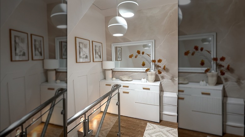 A modern room with a mirror, pink marble wallpaper, and white decor