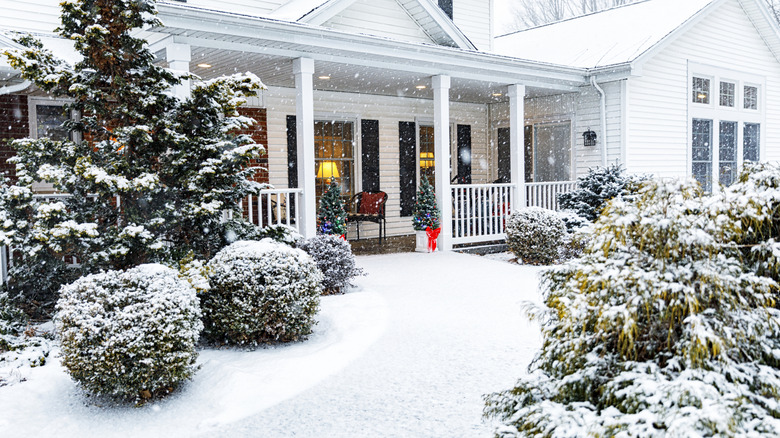 a home decorated for Christmas surrounded by snow