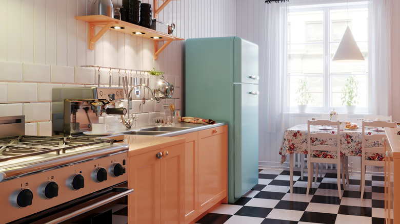 A small retro kitchen with yellow patterned wallpaper and white subway tile.