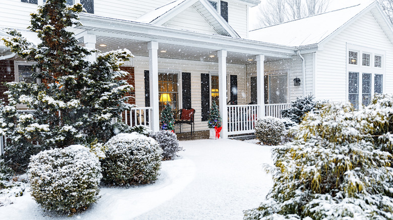 a home's entryway full of snow during the winter