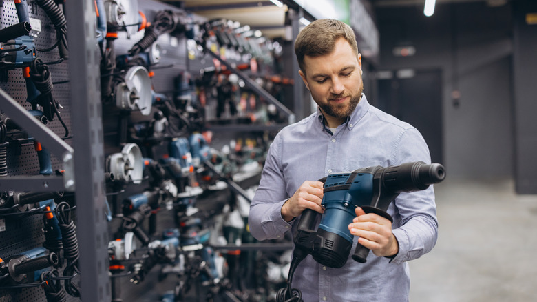 man inspecting tool at store