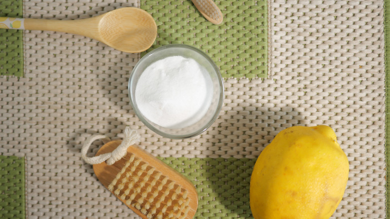 Lemon, baking soda, and cleaning tools on a table