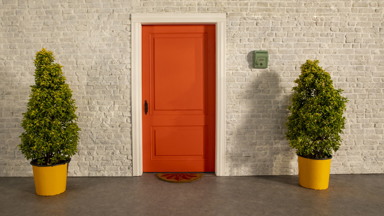 Orange front door in brick home