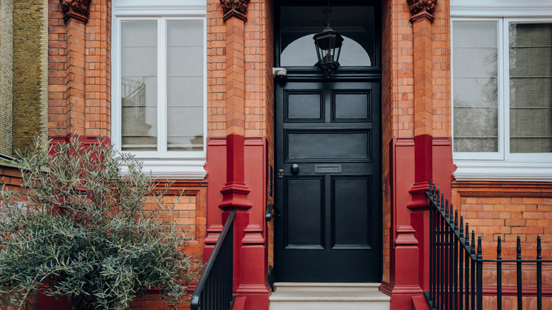 A sleek black front door makes this brick town home look even more sophisticated