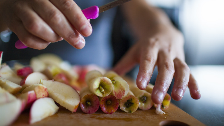 Cut-up apples and a stack of apple cores