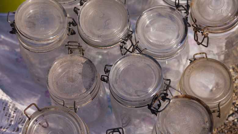 Old mason jars are lined up in an antique market