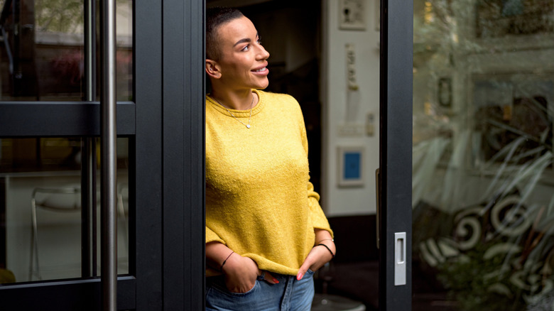 A woman standing in between open pocket doors.