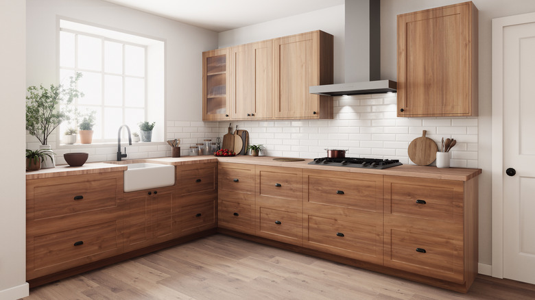 A cozy, modern kitchen with trendy wood cabinets, white tiles, and vinyl plank flooring