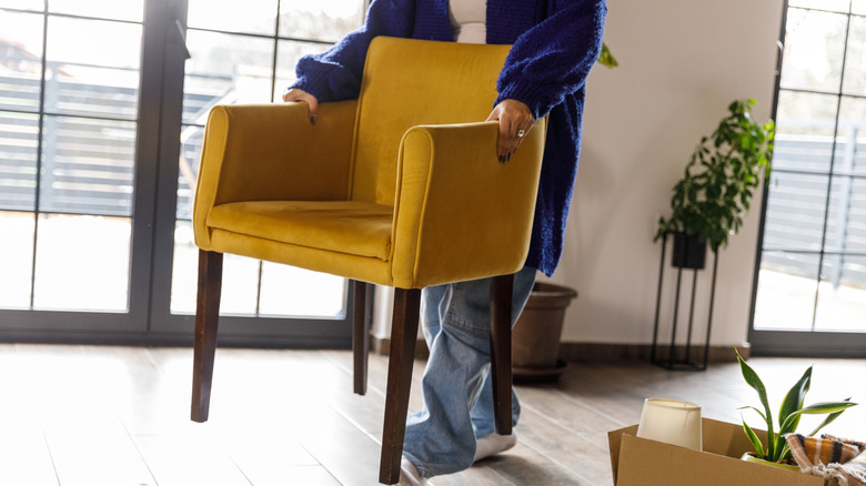 Person moving yellow chair