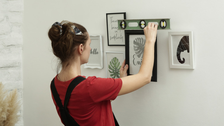 woman hanging a gallery wall