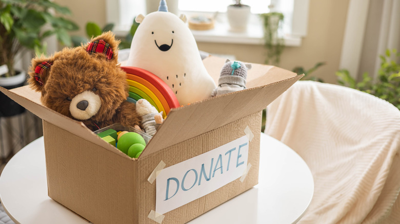 Cardboard box labeled donate sitting on table with toys in it.