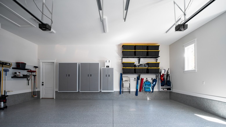 Organized modern garage with wall cabinets, storage shelves, and neatly arranged tools
