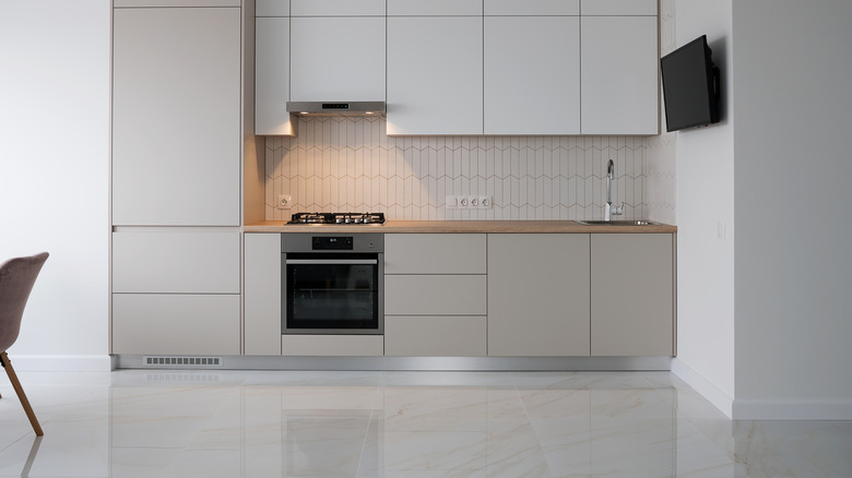Tidy kitchen with glossy off-white tile and off-white cabinets