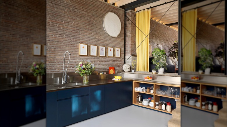 Gray kitchen flooring against navy blue cabinets and stainless steel countertops