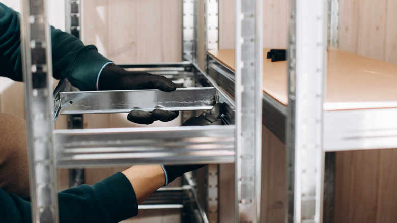 Person assembling garage shelving.