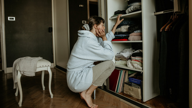 Indecisive person looking at the contents of her closet