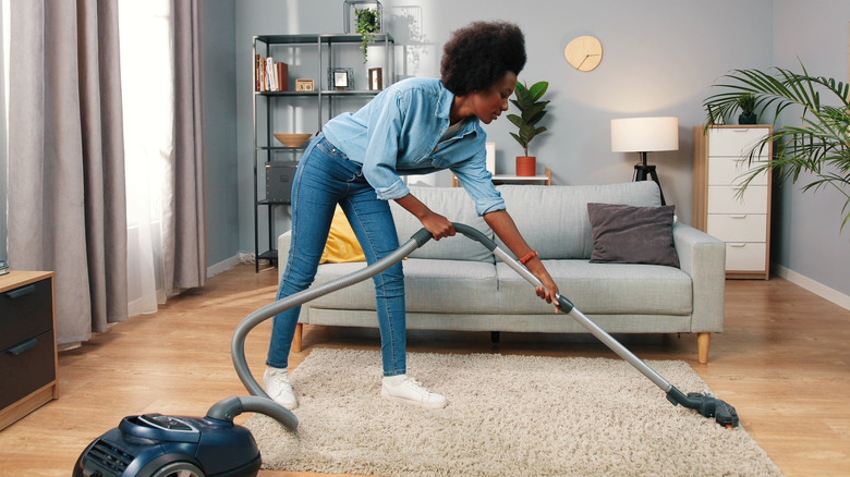woman vacuuming living room carpet
