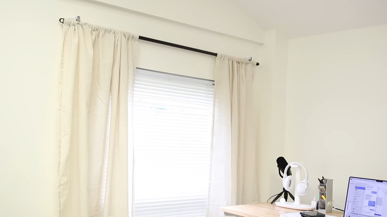 A curtain setup made using a Dollar Tree broomstick and adhesive holders