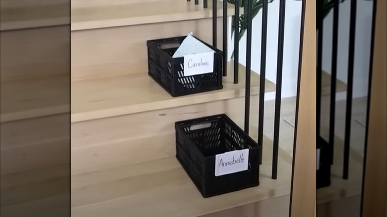 Baskets on staircase with kids' names to help stop clutter