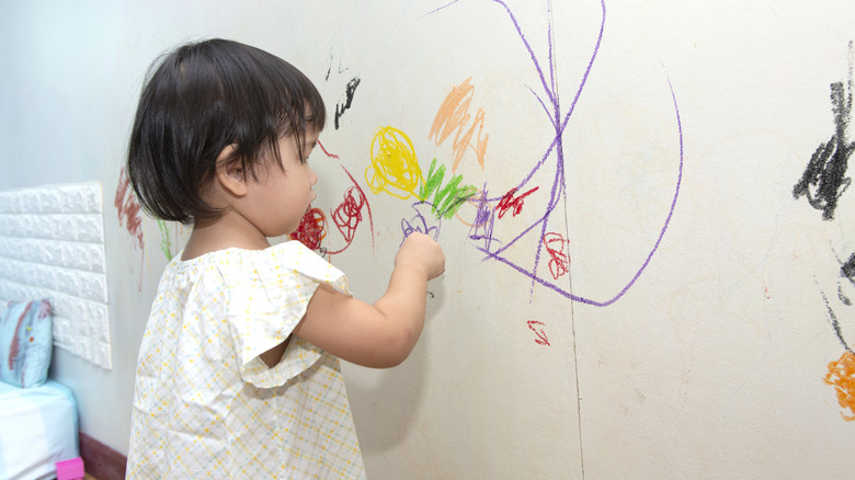 child puts crayon on wall