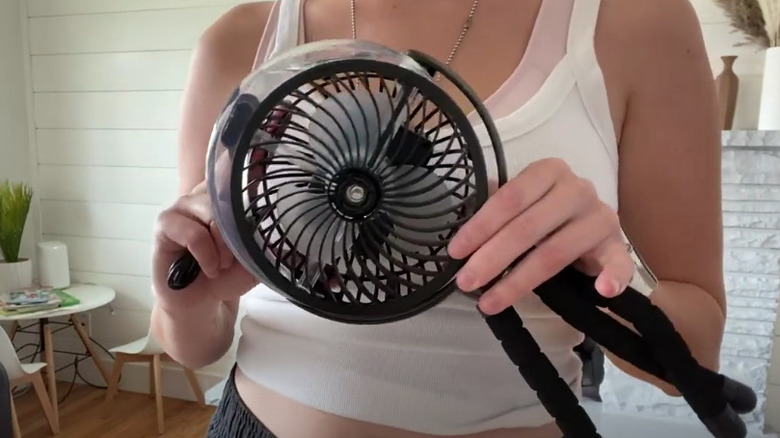 A woman is holding a portable mister fan
