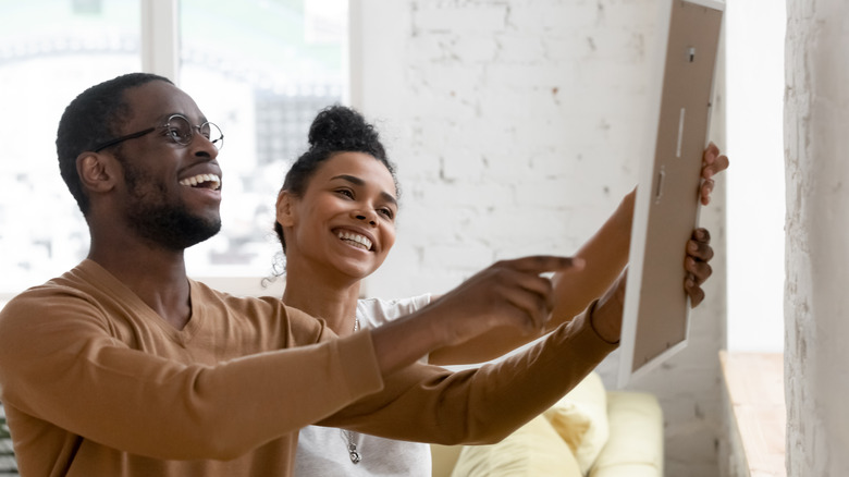 Man and woman hanging picture