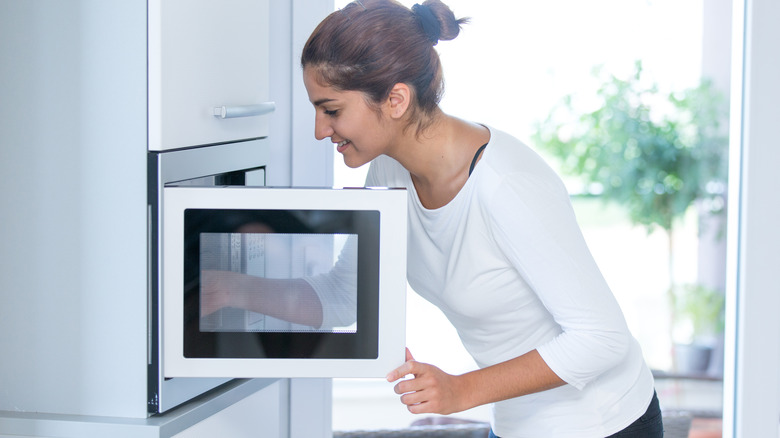 Woman putting something in microwave