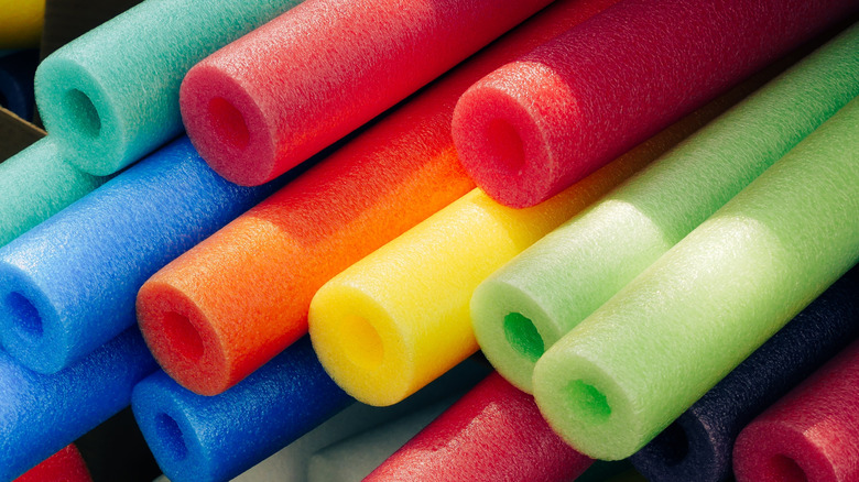 Stack of red, blue, green, and yellow pool noodles