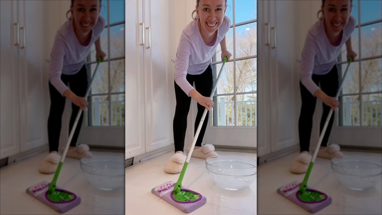 Woman using a Swiffer mop with a pink fuzzy sock on the head
