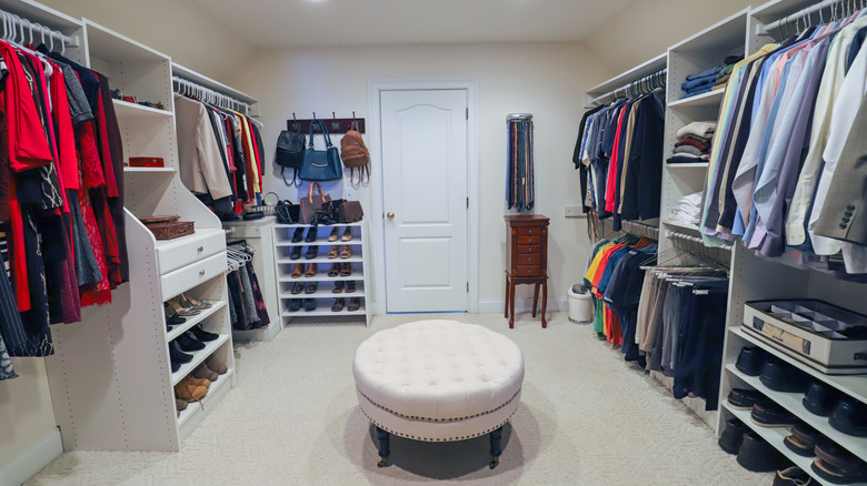 Large walk-in closet with multiple white bookshelves and rails