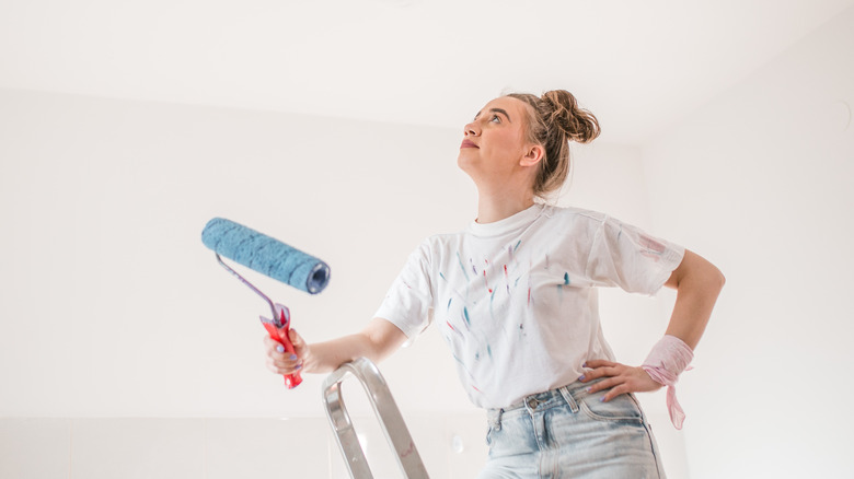 woman about to paint ceiling