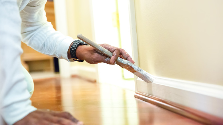 Man painting baseboards