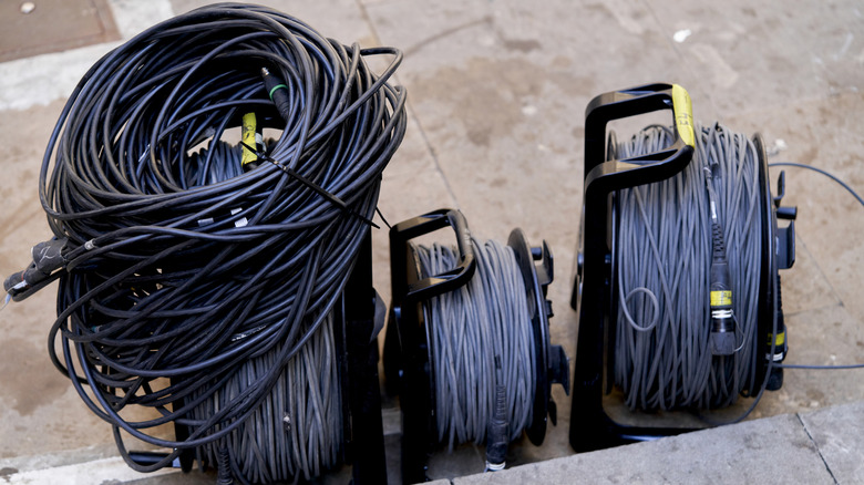 Three sets of cables stored on spools and one cable tied with a zip tie