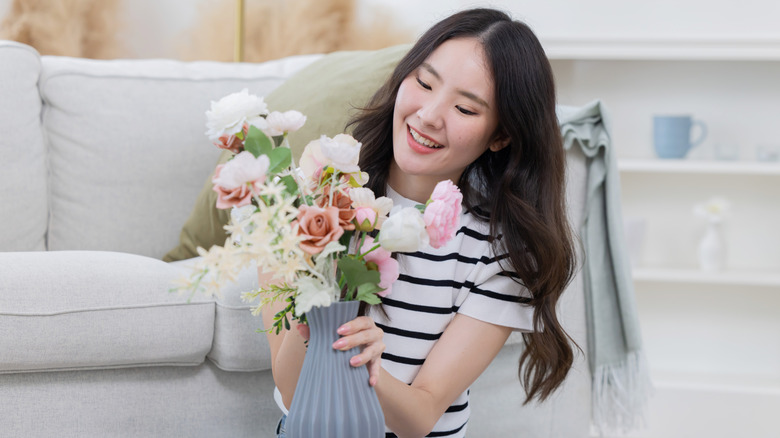 woman admiring flowers in vase