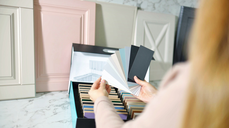 Woman hold color samples for kitchen cabinets