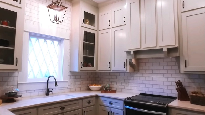 A kitchen design from Home Town season 1 episode 6 with white cabinets and subway tile backsplash.