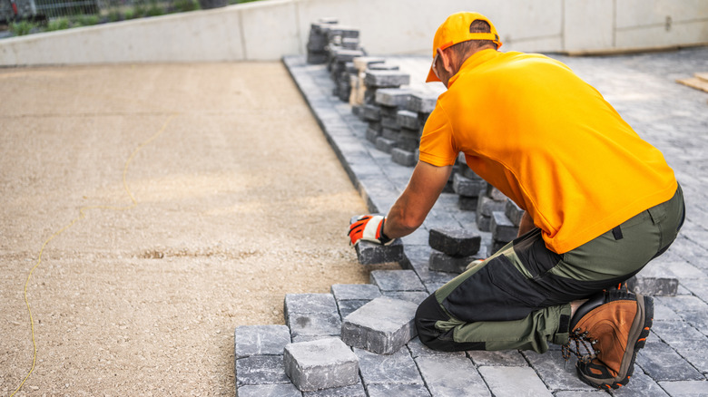 Worker installing a cobblestone floor