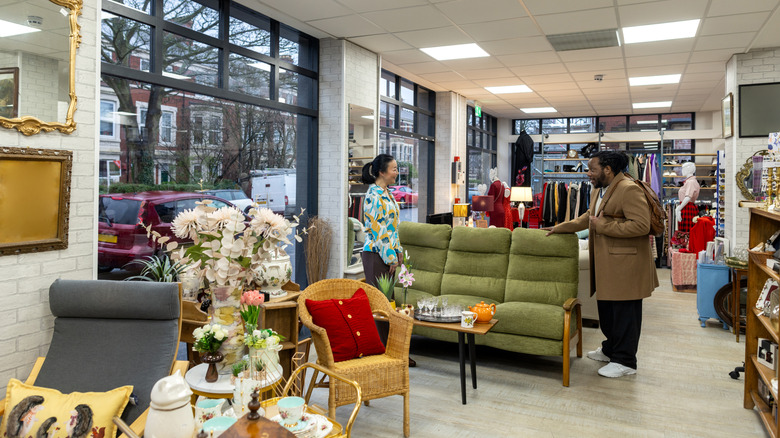 Two people examine furniture in a thrift store