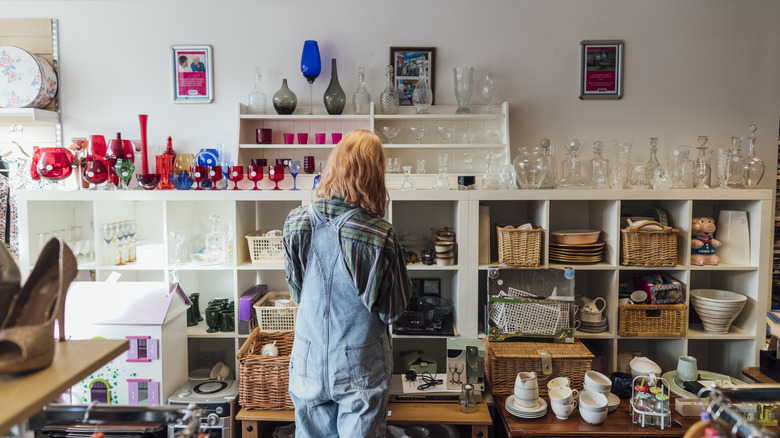 A woman shops for items at a thrift store