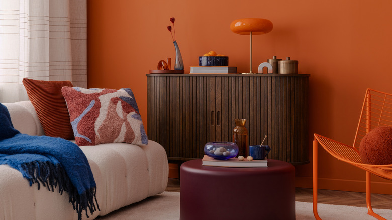 curved sofa with fluted curved accent table and round ottoman in small living room