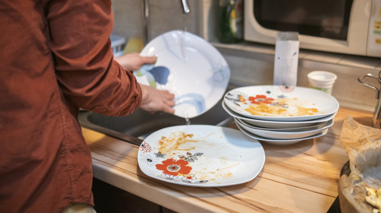 Person washing dirty dishes