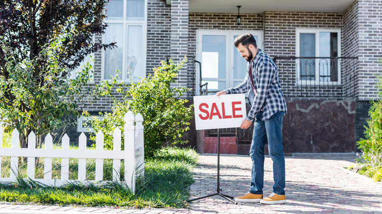 Man putting sale sign up