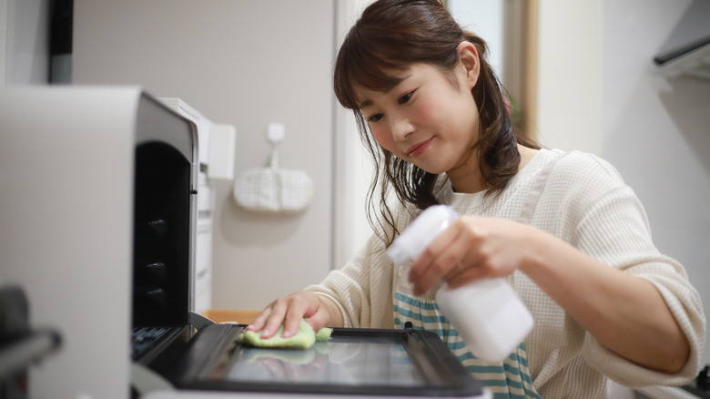 Woman cleaning toaster oven