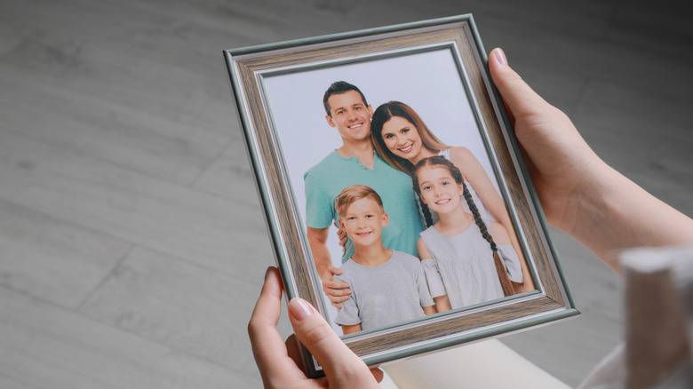 person holding framed family photo