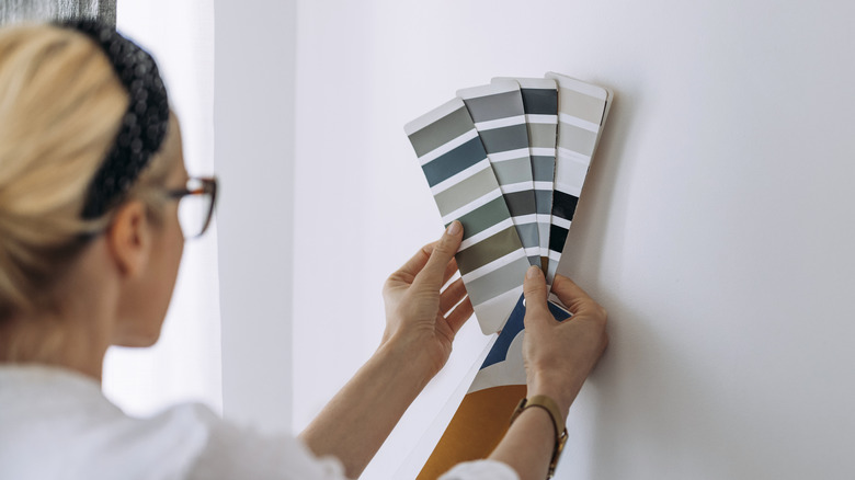 woman trying to match wall paint