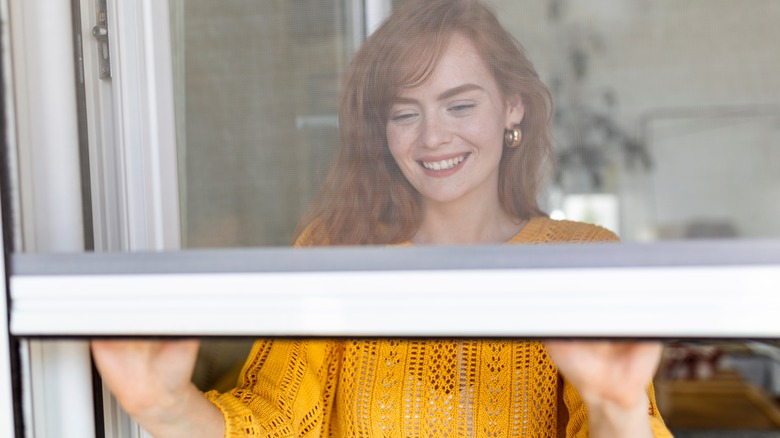 woman opening window 